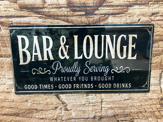 Decoratief bord met zwarte achtergrond en witte en gouden tekst “BAR & LOUNGE – Proudly Serving WHATEVER YOU BROUGHT – GOOD TIMES • GOOD FRIENDS • GOOD DRINKS”, gemonteerd op hout met een informele en gastvrije uitstraling.