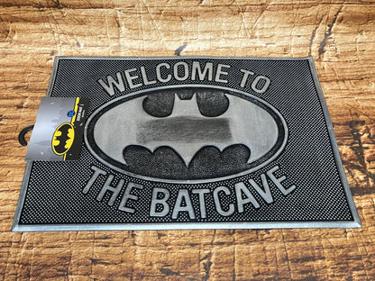 Zwart‑grijze Batman‑deurmat met het vleermuislogo en de tekst “Welcome to the Batcave".