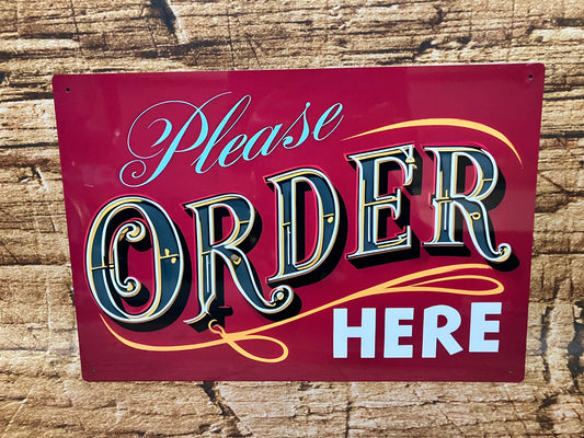 Decoratief bord met rode achtergrond en opvallende tekst “Please ORDER HERE”, waarbij “ORDER” groot en kleurrijk is vormgegeven in vintage stijl, gemonteerd op een houten oppervlak voor gebruik in horeca of foodservice.