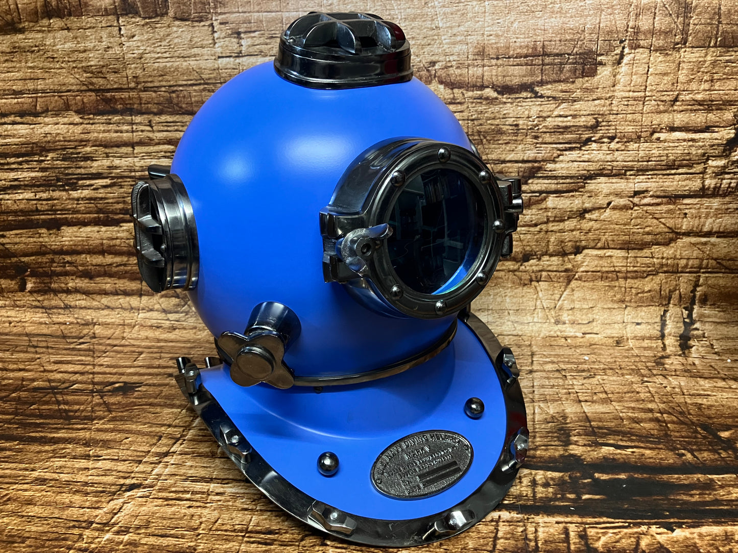 "Blauwe vintage U.S. Navy Mark V duikhelm met metalen accenten, meerdere kijkvensters en DESCO‑plaquette uit 1944, gebruikt als maritieme decoratie."