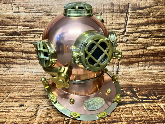 "Koperen en messing vintage Siebe Gorman duikhelm met meerdere kijkvensters en plaquette ‘Submarine Engineers London’, gebruikt als maritieme decoratie."