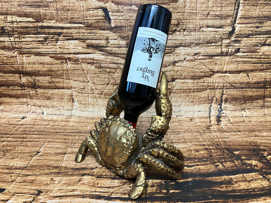 Metalen krab‑wijnfleshouder die een wijnfles rechtop vasthoudt.