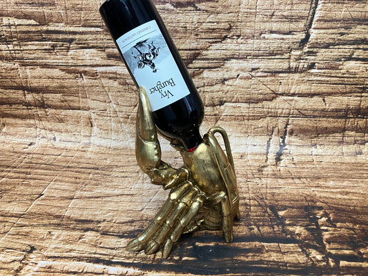 Goudkleurige kreeft‑wijnfleshouder die een wijnfles vasthoudt.