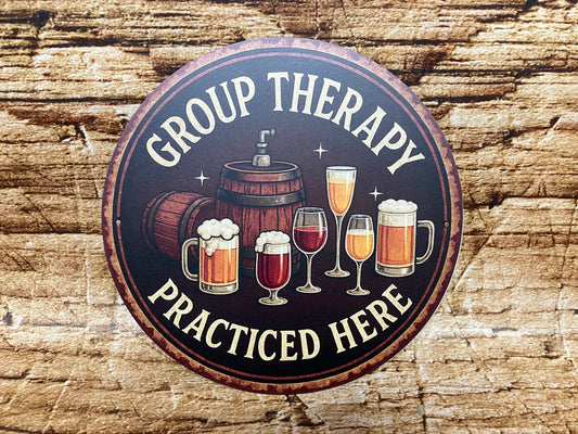 Rond decoratief bord met illustraties van bierpullen, wijnglazen en een tapvat, met de humoristische tekst “GROUP THERAPY PRACTICED HERE” op een rustieke houten achtergrond.