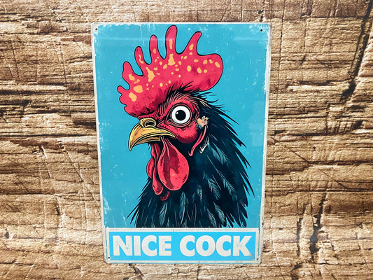 Humoristisch bord met een gestileerde haan en de tekst “NICE COCK” in witte hoofdletters op een blauwe achtergrond, bedoeld als speelse woordgrap met opvallende illustratie.