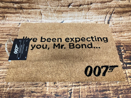 Lichtbruine deurmat met zwarte tekst “I’ve been expecting you, Mr. Bond…” en het 007‑logo met pistool.