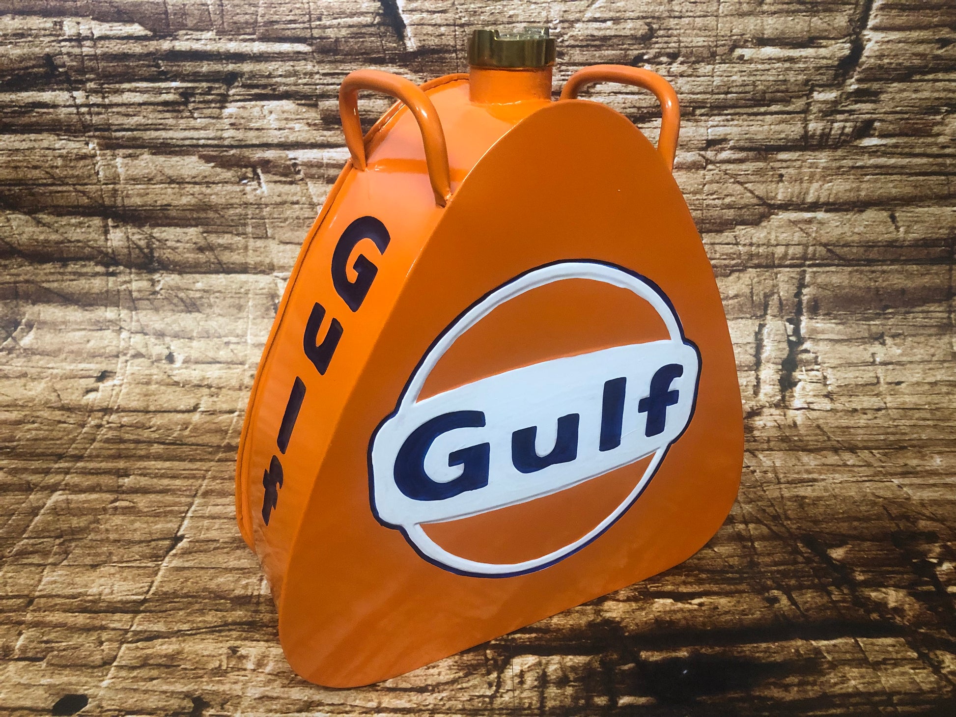 Metalen jerrycan met messing dop in de kleur oranje bedrukt met het merk Gulf.