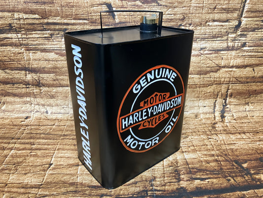  “Zwarte vintage Harley‑Davidson motoroliecontainer met oranje‑wit logo, gebruikt als retro motor- en garage decoratie.”