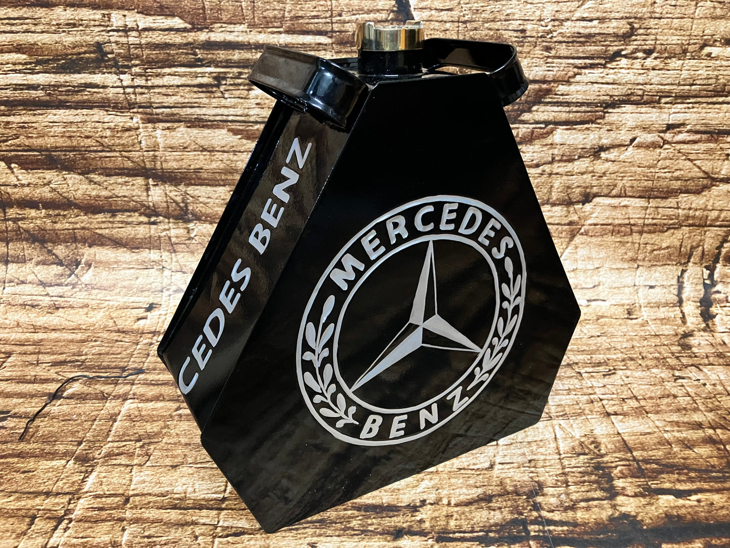 “Zwarte metalen Mercedes‑Benz tank met glanzende afwerking en klassiek Mercedes‑logo, gebruikt als vintage garage en oldtimer decoratie.”
