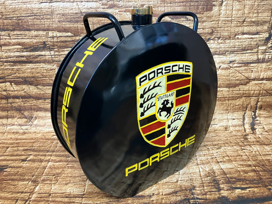 “Zwarte ronde metalen Porsche‑container met klassiek Porsche‑embleem en messing dop, gebruikt als luxe automotive decoratie.”