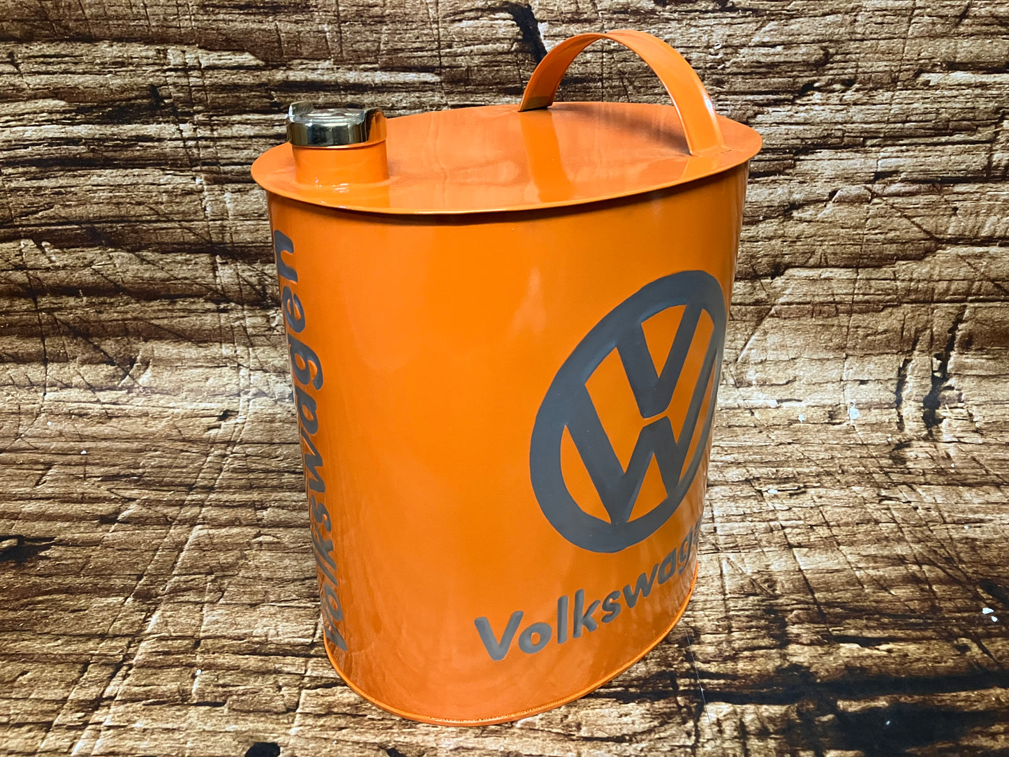 “Oranje metalen vintage jerrycan met grijs Volkswagen‑logo, voorzien van handgreep en schroefdop"