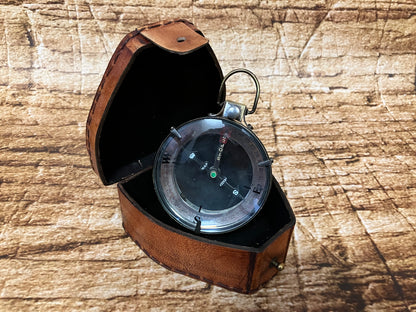 "Vintage metalen kompas in bruine leren etui met gradenring en ‘Stoper Map Reading’ wijzerplaat, gebruikt als decoratief en verzamelobject."
