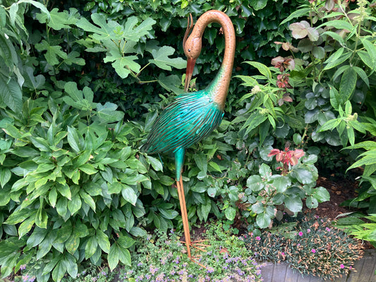 Metalen reiger sculptuur met groen‑beige afwerking, gebogen hals en gedetailleerde veren