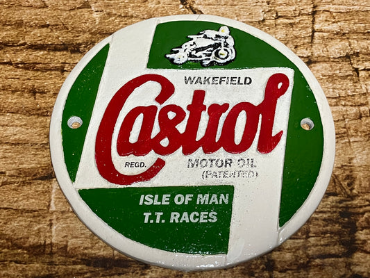 Ronde metalen Castrol‑plaat met groen‑wit ontwerp, rood Castrol‑logo en verwijzing naar Isle of Man TT‑races, geschikt als retro wanddecoratie voor garage of mancave.