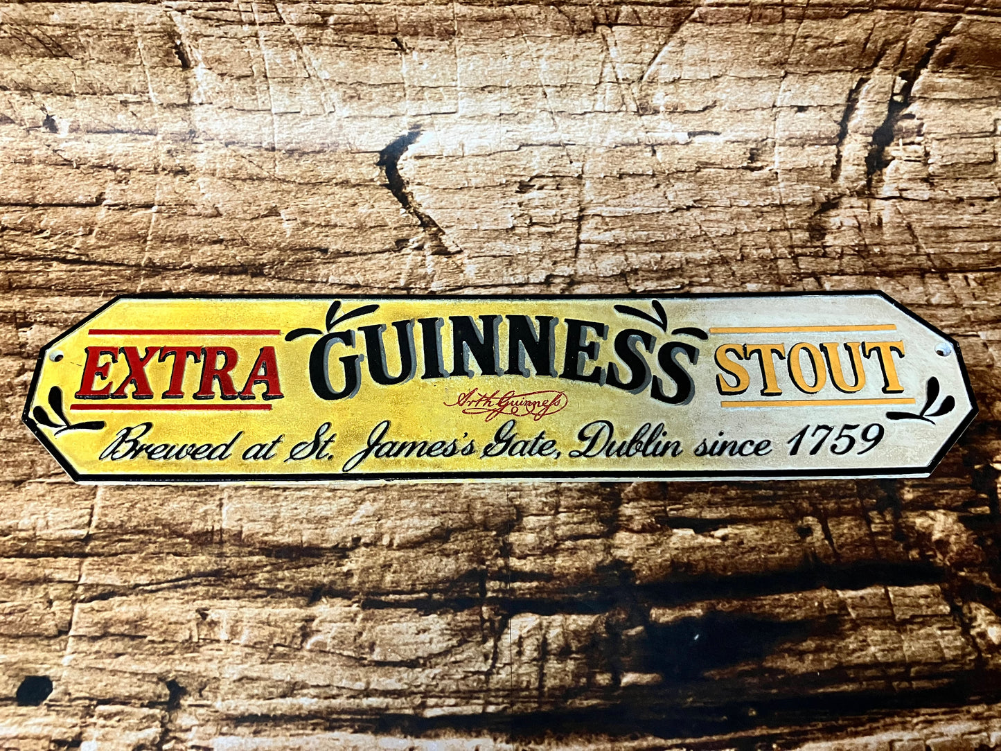 Vintage metalen Guinness reclamebord met tekst “Extra Guinness Stout – Brewed at St. James’s Gate, Dublin since 1759”