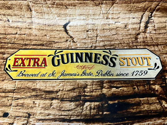 Vintage metalen Guinness reclamebord met tekst “Extra Guinness Stout – Brewed at St. James’s Gate, Dublin since 1759”