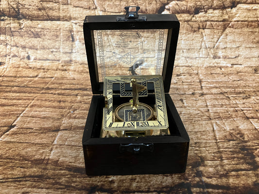 "Vintage zonnewijzer‑kompas in zwarte box met metalen frame, Romeinse cijfers en ingebouwd kompas, gebruikt als decoratief en verzamelobject."