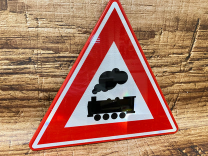 Metalen driehoekig waarschuwingsbord met rode rand en zwarte stoomlocomotief op witte achtergrond