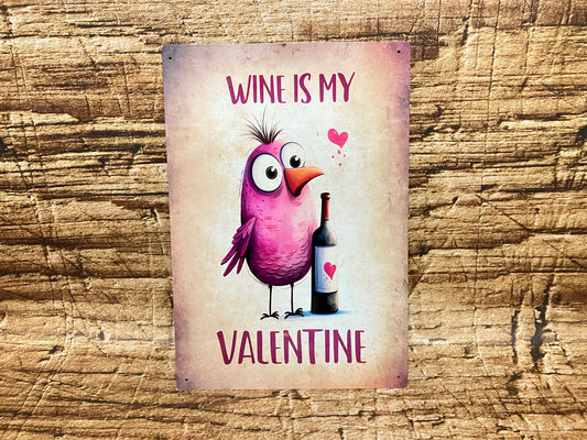 Humoristisch decoratief bord met een paarse cartoonvogel naast een wijnfles met hartlabel, omringd door roze hartjes en de tekst “WINE IS MY VALENTINE” op een rustieke achtergrond.
